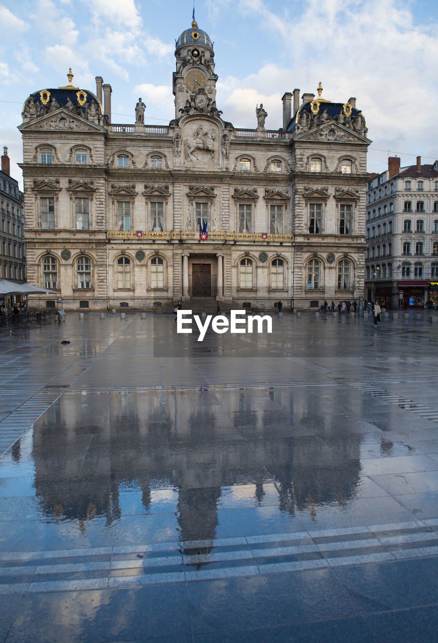architecture, reflection, building exterior, built structure, landmark, travel destinations, water, city, sky, palace, history, the past, travel, nature, cityscape, cloud, tourism, town square, building, château, politics and government, government, plaza, outdoors, facade, urban area, business finance and industry, no people, mansion