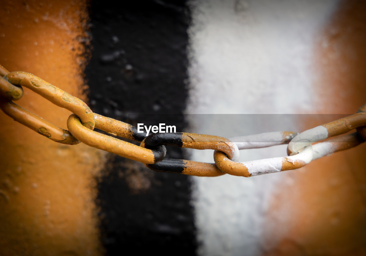 Close-up of rusty chain against wall