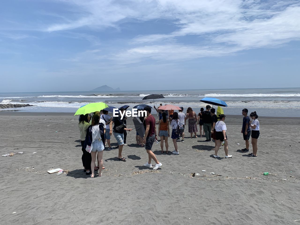 GROUP OF PEOPLE AT BEACH AGAINST SKY