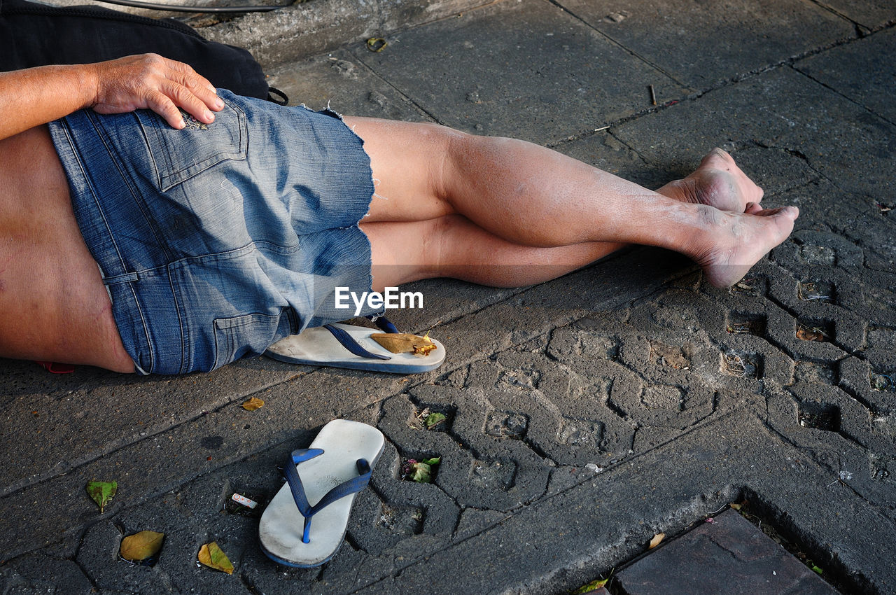Low section of man relaxing on sidewalk