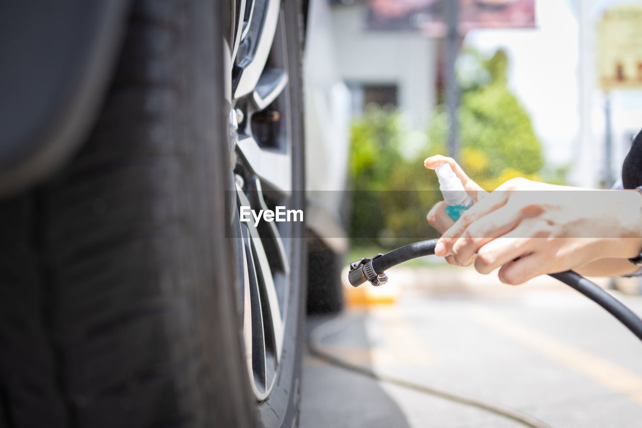 MIDSECTION OF MAN HOLDING CAR MOVING