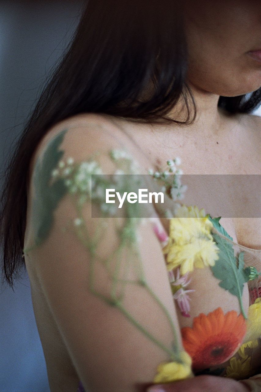 Cropped image of naked woman covered with flowers