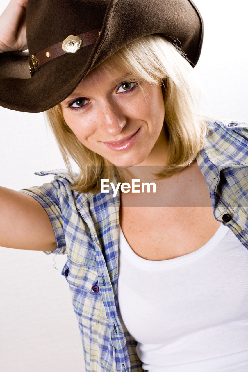 PORTRAIT OF A SMILING YOUNG WOMAN WITH HAT