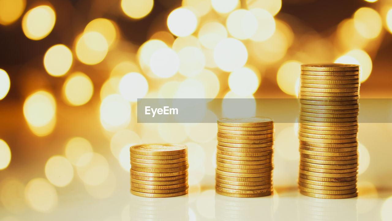 Close-up of coins on table against illuminated lights