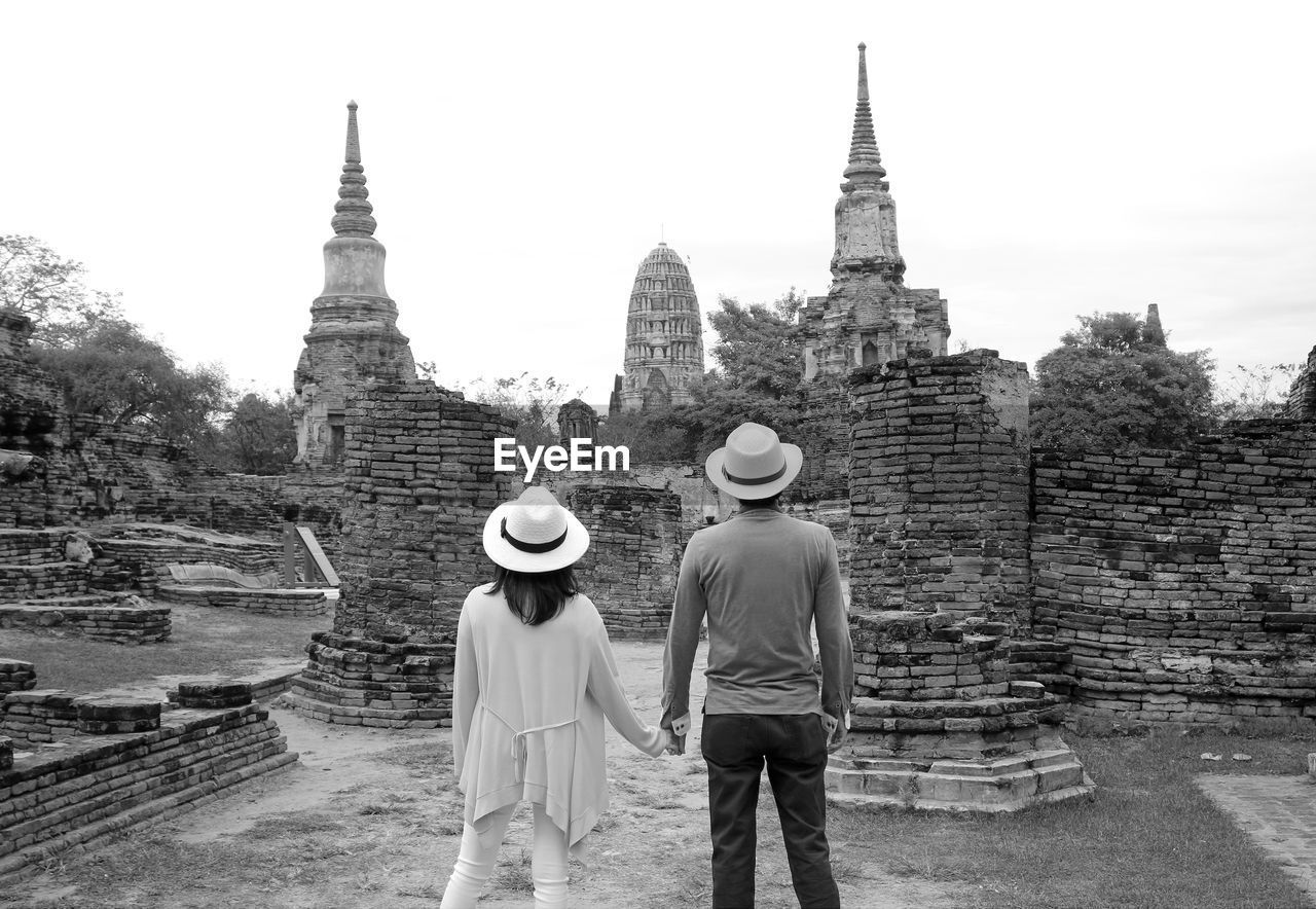 Monochrome image of young couple visiting temple ruins in the ayutthaya historical park, thailand