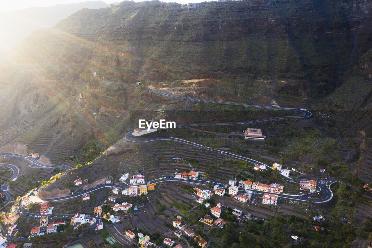 Spain, valle gran rey, drone view of village and winding road in valley of la gomera