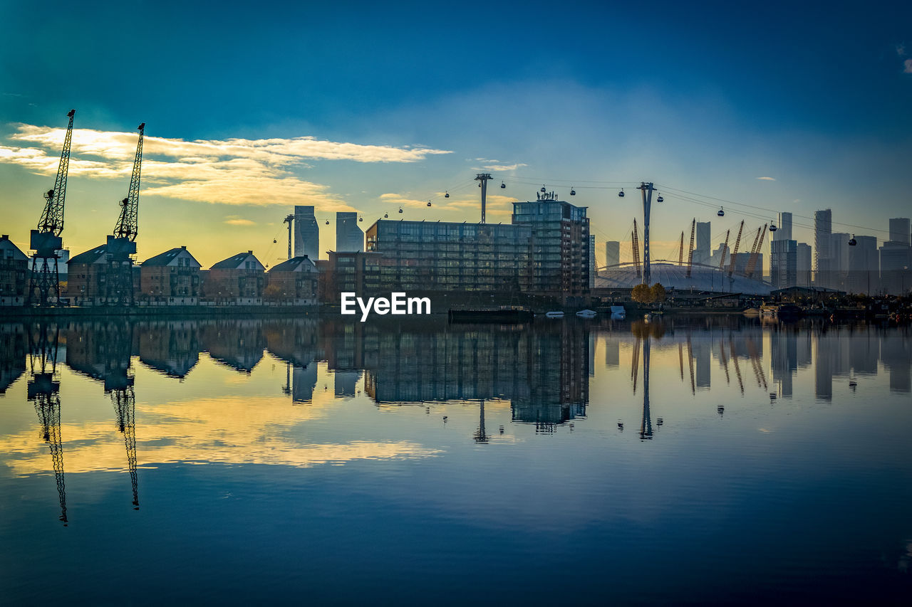 Reflection of buildings in dock during sunset