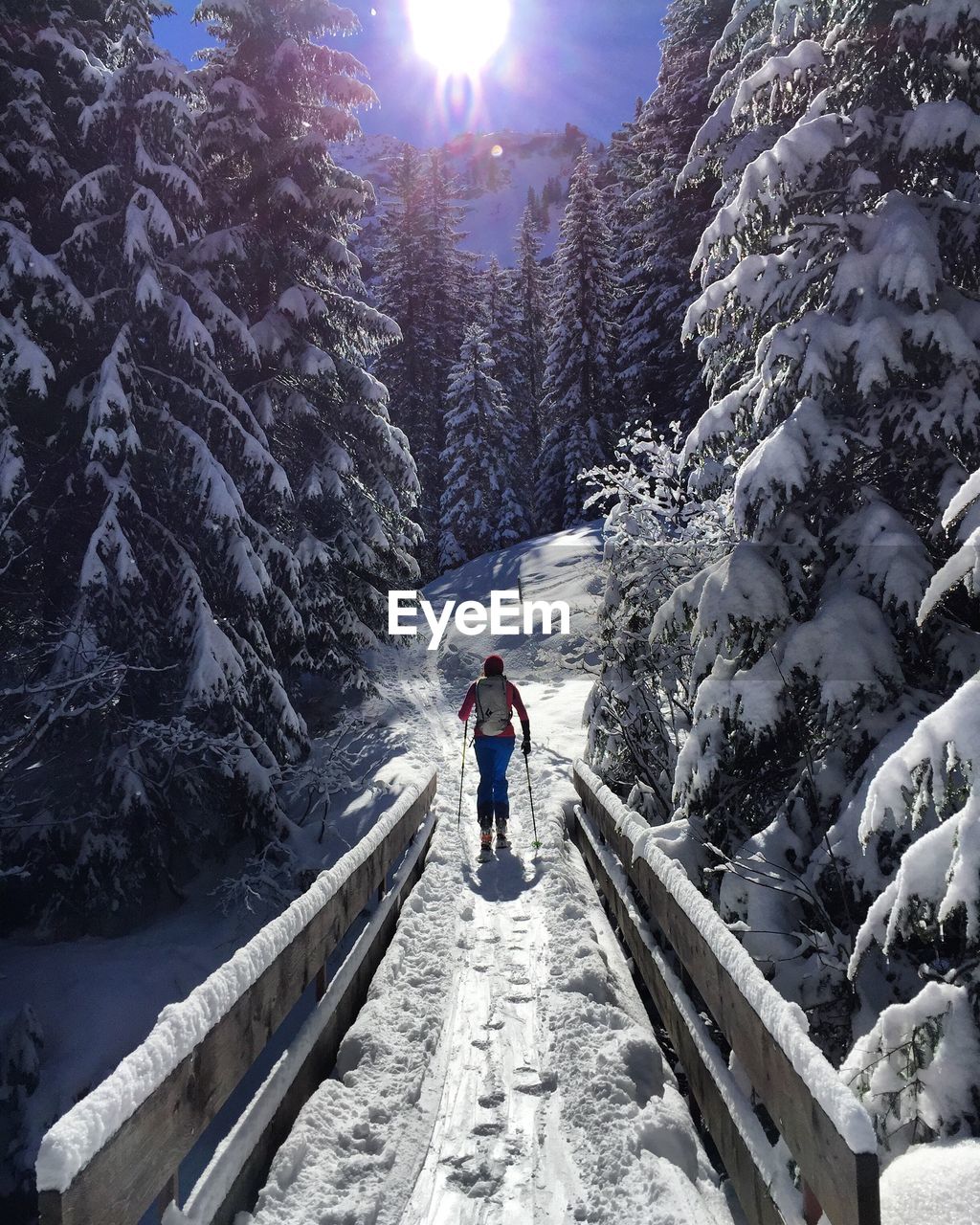 Rear view of woman skiing on snow covered field