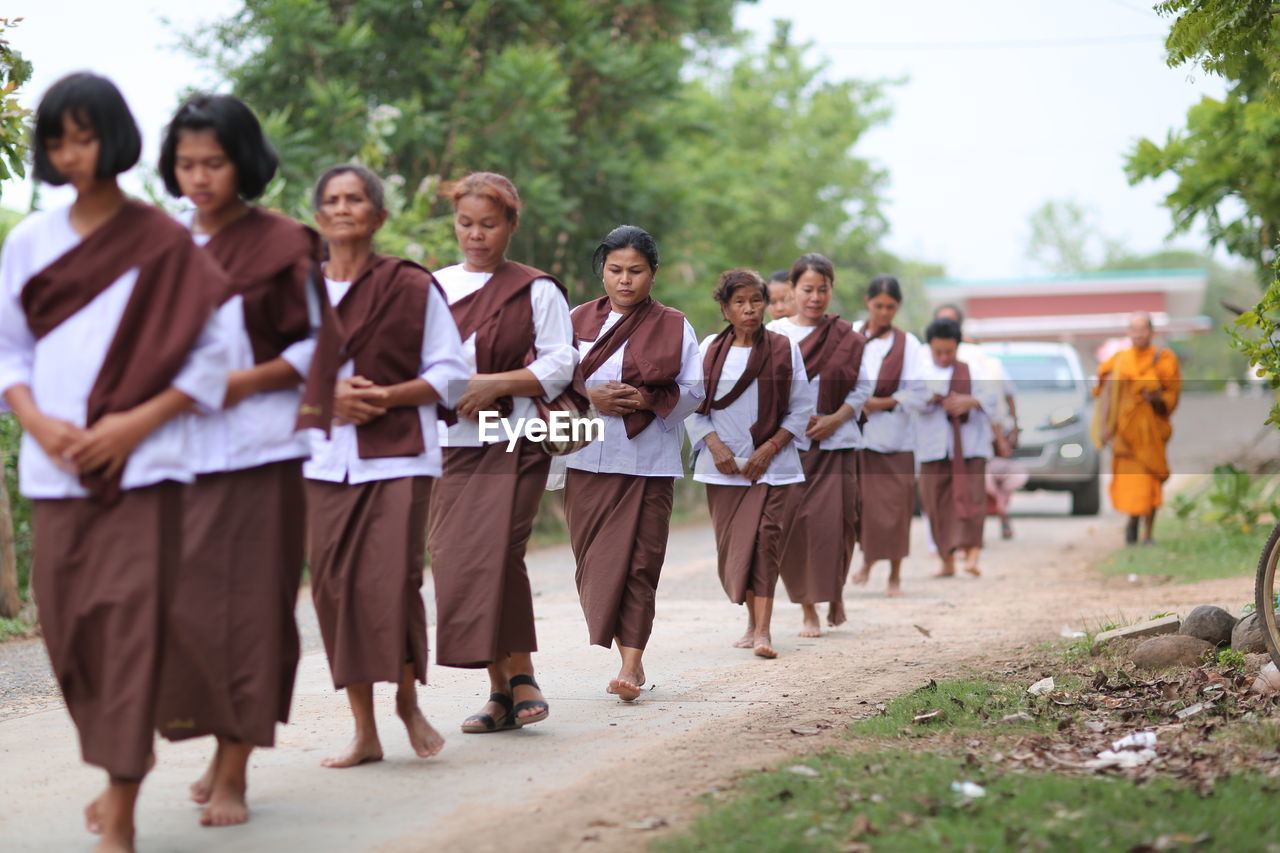 GROUP OF PEOPLE WALKING ON STREET