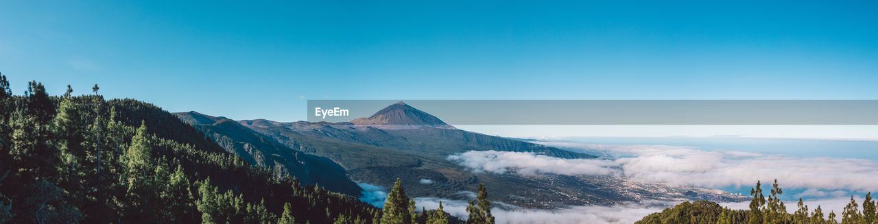 Scenic view of snowcapped mountains against blue sky