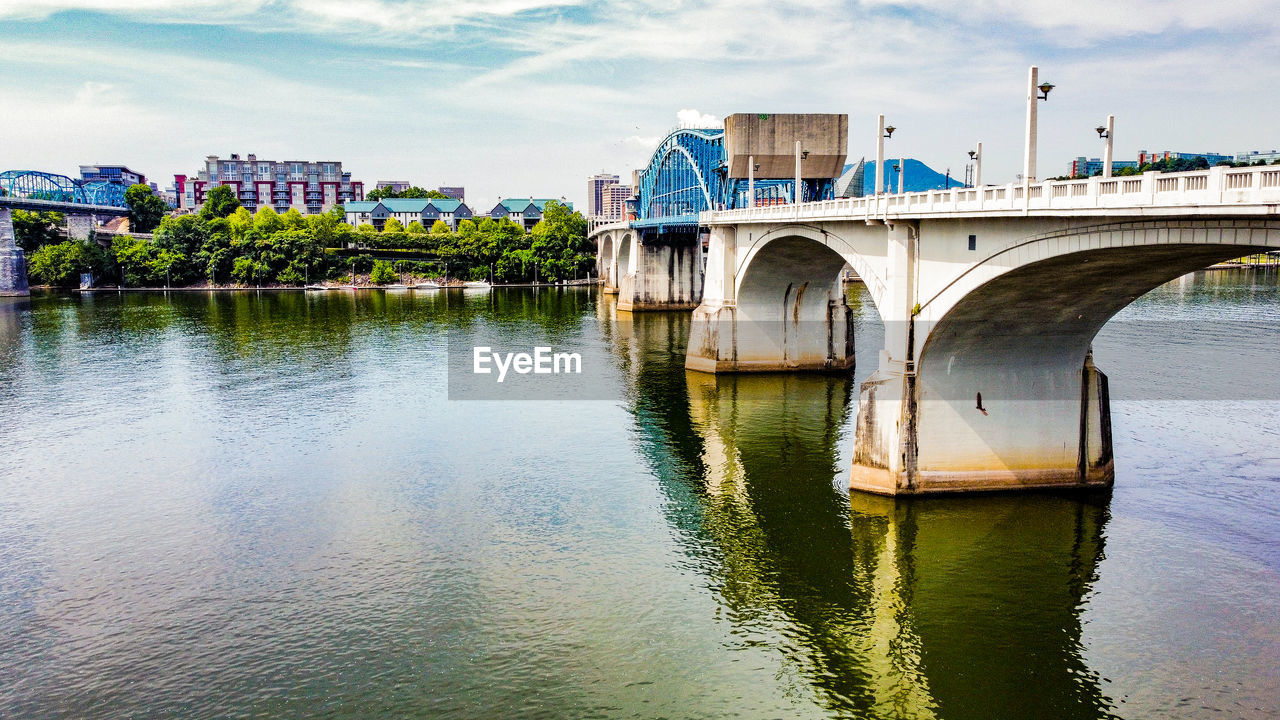 water, architecture, built structure, bridge, river, reflection, transportation, sky, city, building exterior, waterway, nature, travel destinations, cloud, travel, no people, building, outdoors, tourism, landscape, day, nautical vessel, environment, cityscape, mode of transportation, waterfront, tree