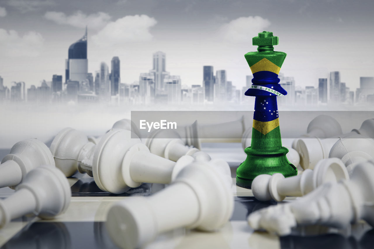 Digital composite image of chess pieces with flag against buildings in city