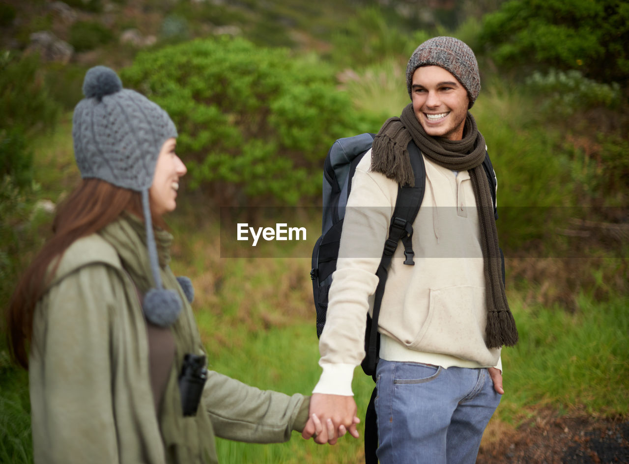 two people, adult, togetherness, men, clothing, women, emotion, forest, happiness, smiling, nature, leisure activity, hat, young adult, tree, hiking, positive emotion, friendship, land, lifestyles, knit hat, plant, warm clothing, winter, walking, vacation, autumn, bonding, trip, female, travel, holiday, adventure, jacket, love, landscape, outdoors, person, standing, activity, human face, cheerful, travel destinations, casual clothing, day, non-urban scene, relaxation, enjoyment, exploration, tourism, environment, looking, backpack, cold temperature