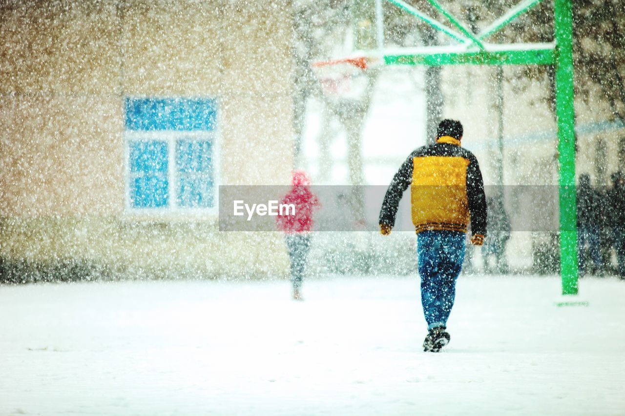 REAR VIEW OF MAN ON SNOW