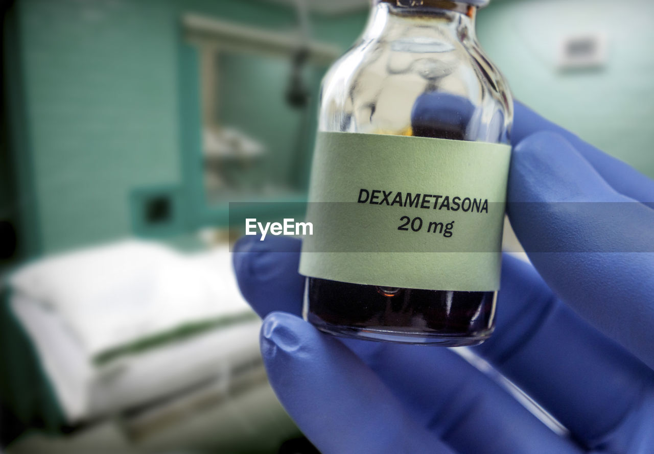 Cropped hand of doctor holding dexametasone in container