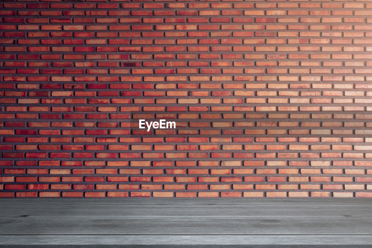 FULL FRAME SHOT OF BRICK WALL WITH BUILDING