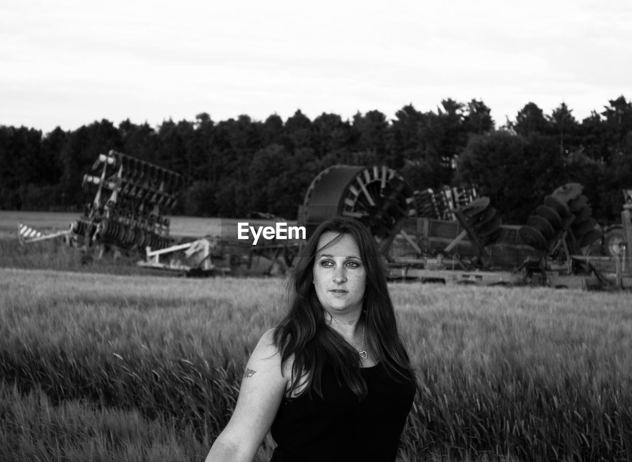 Thoughtful woman looking away while standing at farm