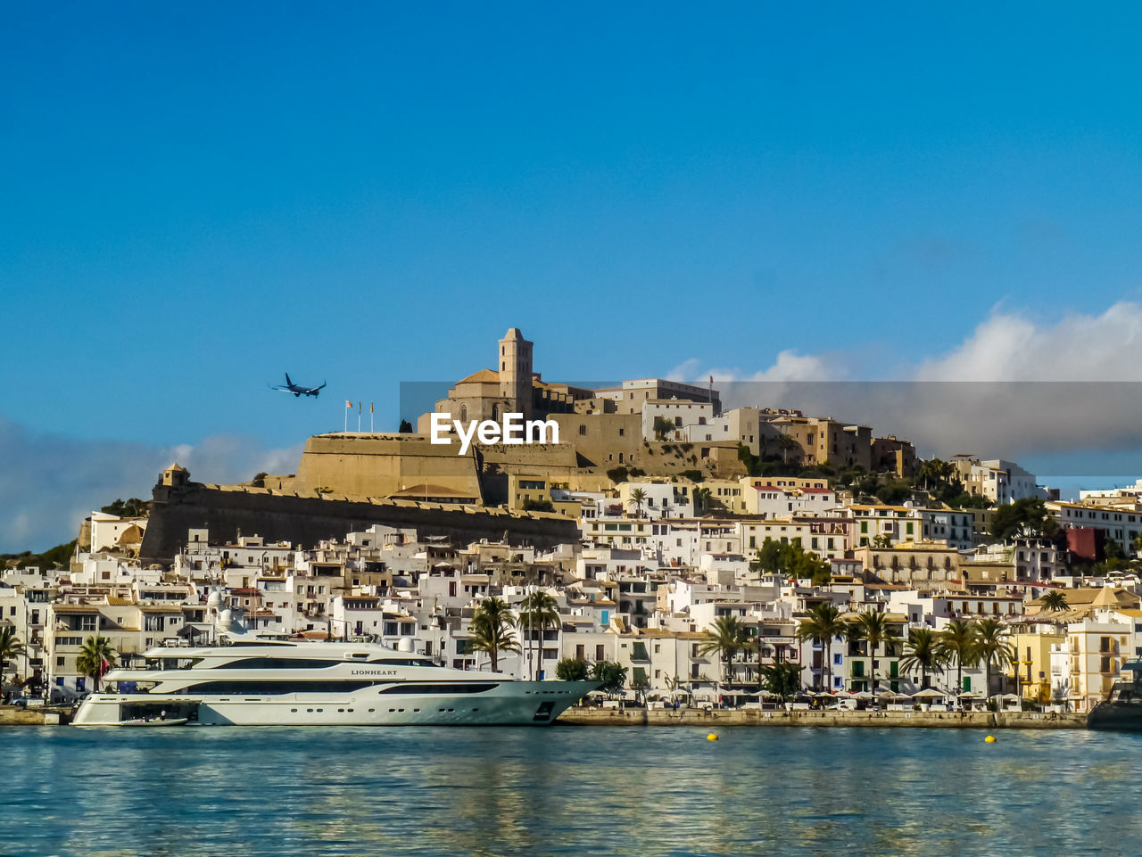 BUILDINGS BY SEA AGAINST SKY IN CITY