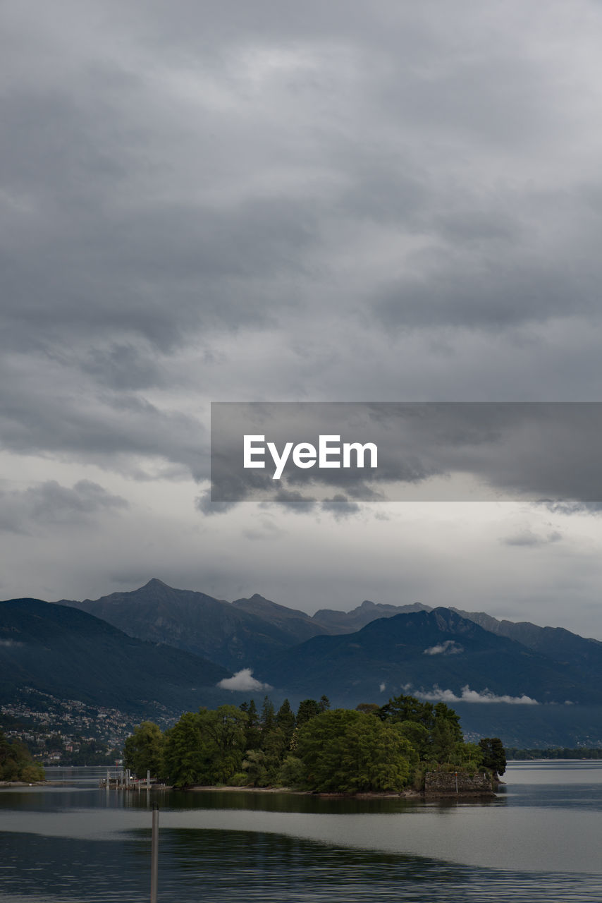 Scenic view of river by mountains against sky