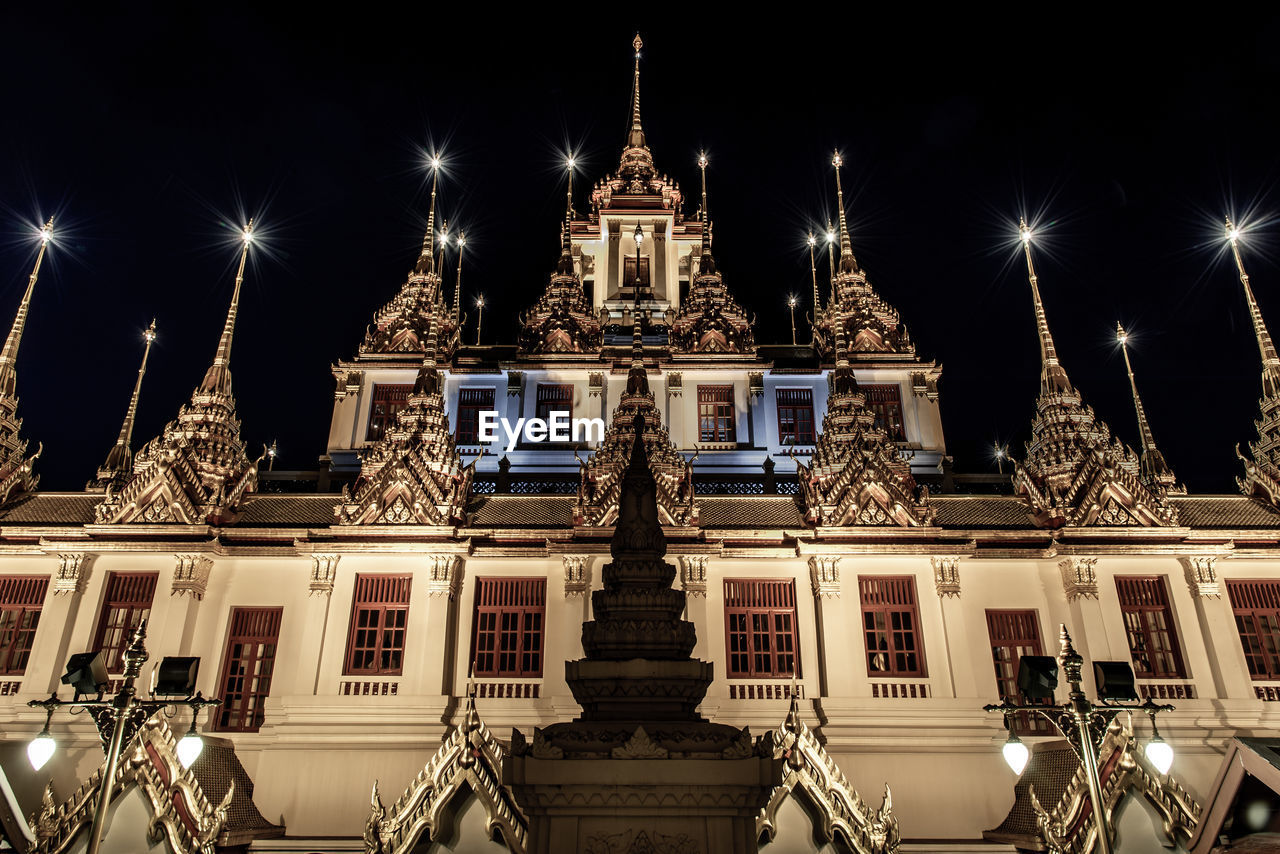 LOW ANGLE VIEW OF ILLUMINATED BUILDING AGAINST SKY