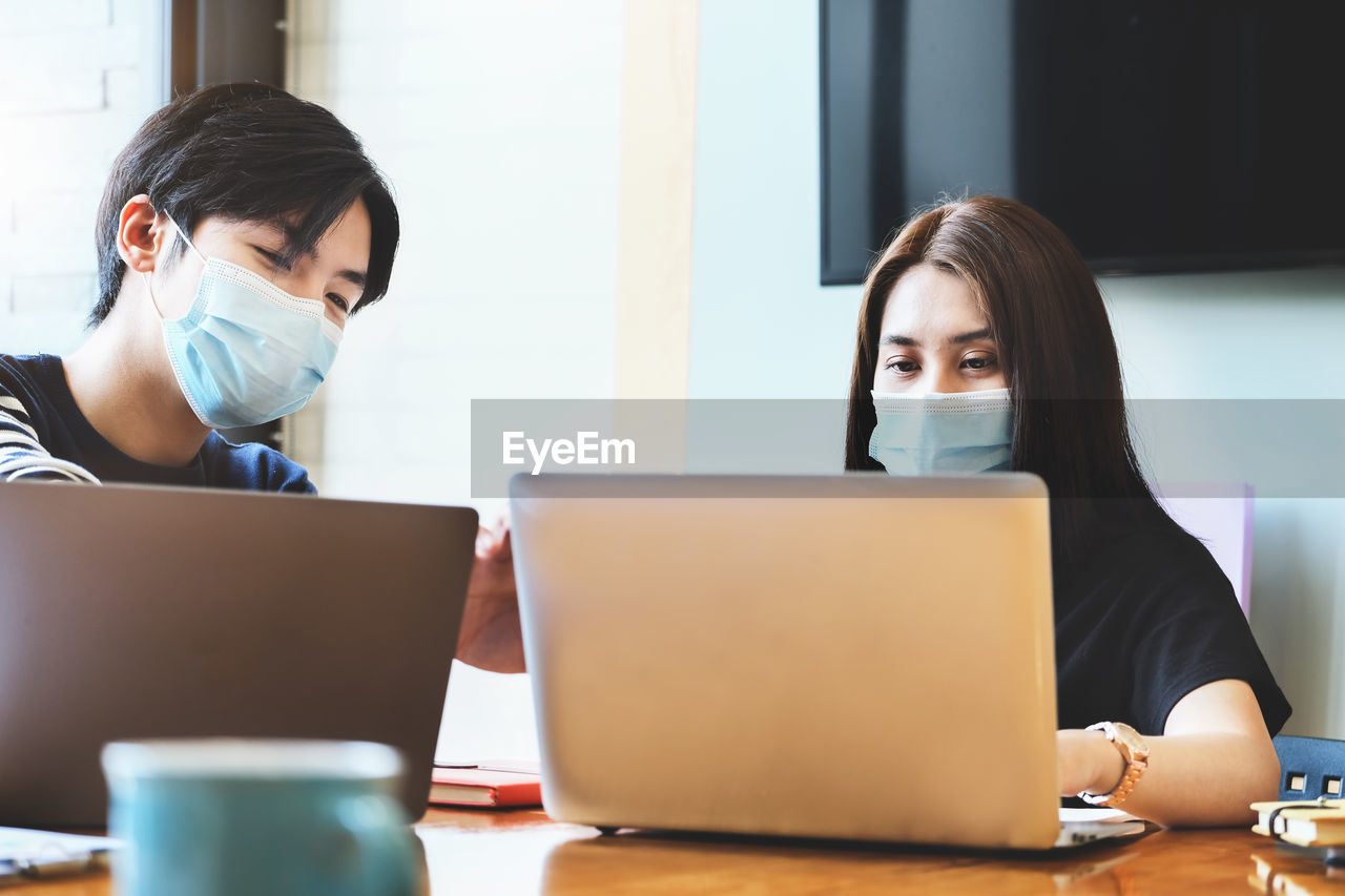 PORTRAIT OF WOMAN WORKING WITH LAPTOP