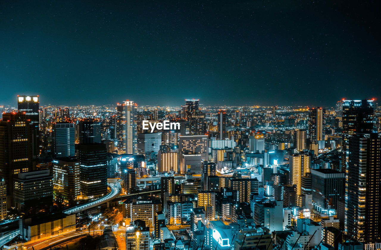 Illuminated cityscape against sky at night in osaka