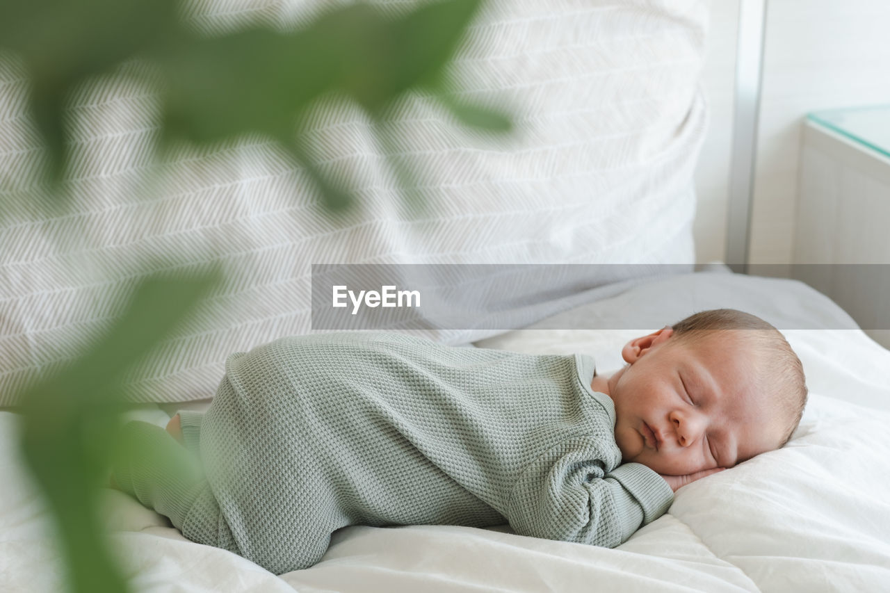 High angle view of baby boy sleeping on bed at home