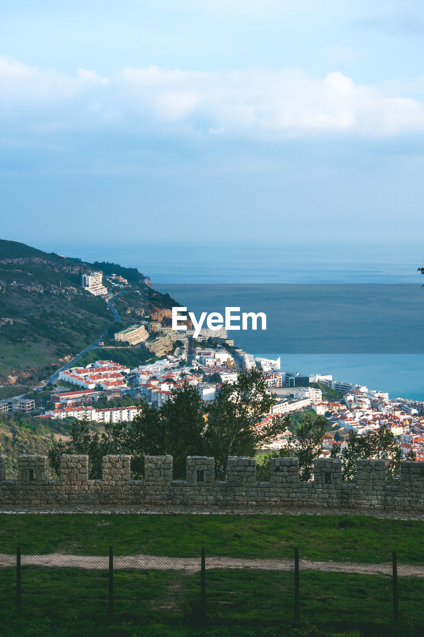 Scenic view of townscape by sea against sky