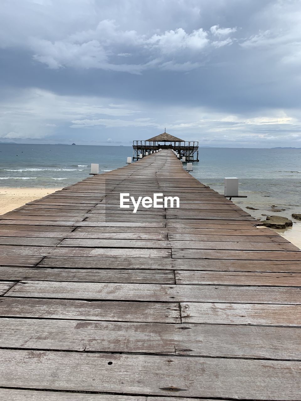 WOODEN PIER ON SEA AGAINST SKY