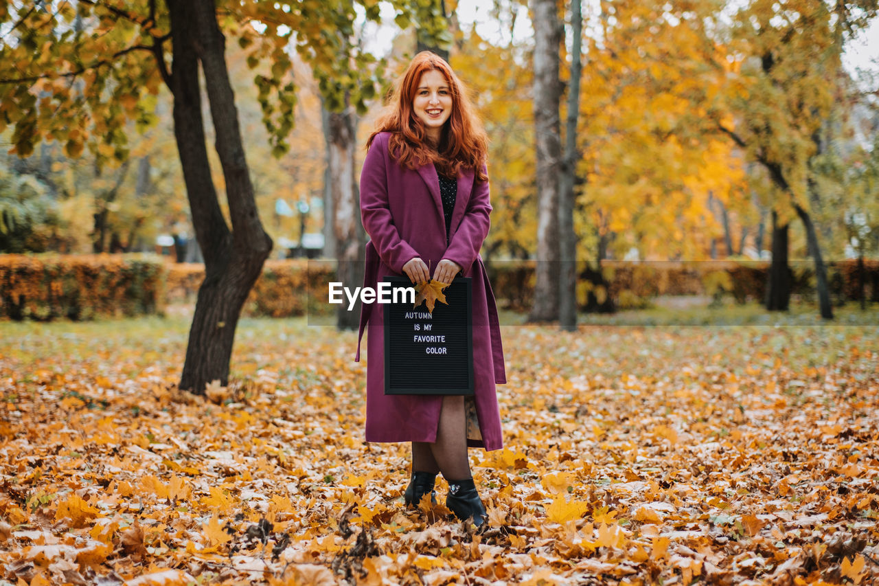 Hello autumn. red hair girl with letter message board with text autumn is my favorite color