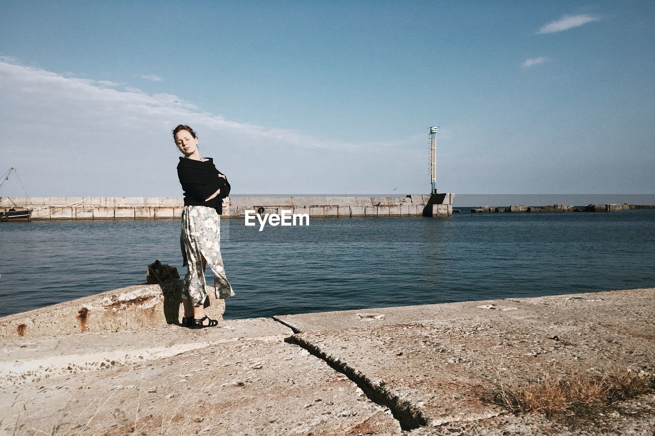 Full length of woman standing at promenade against sky