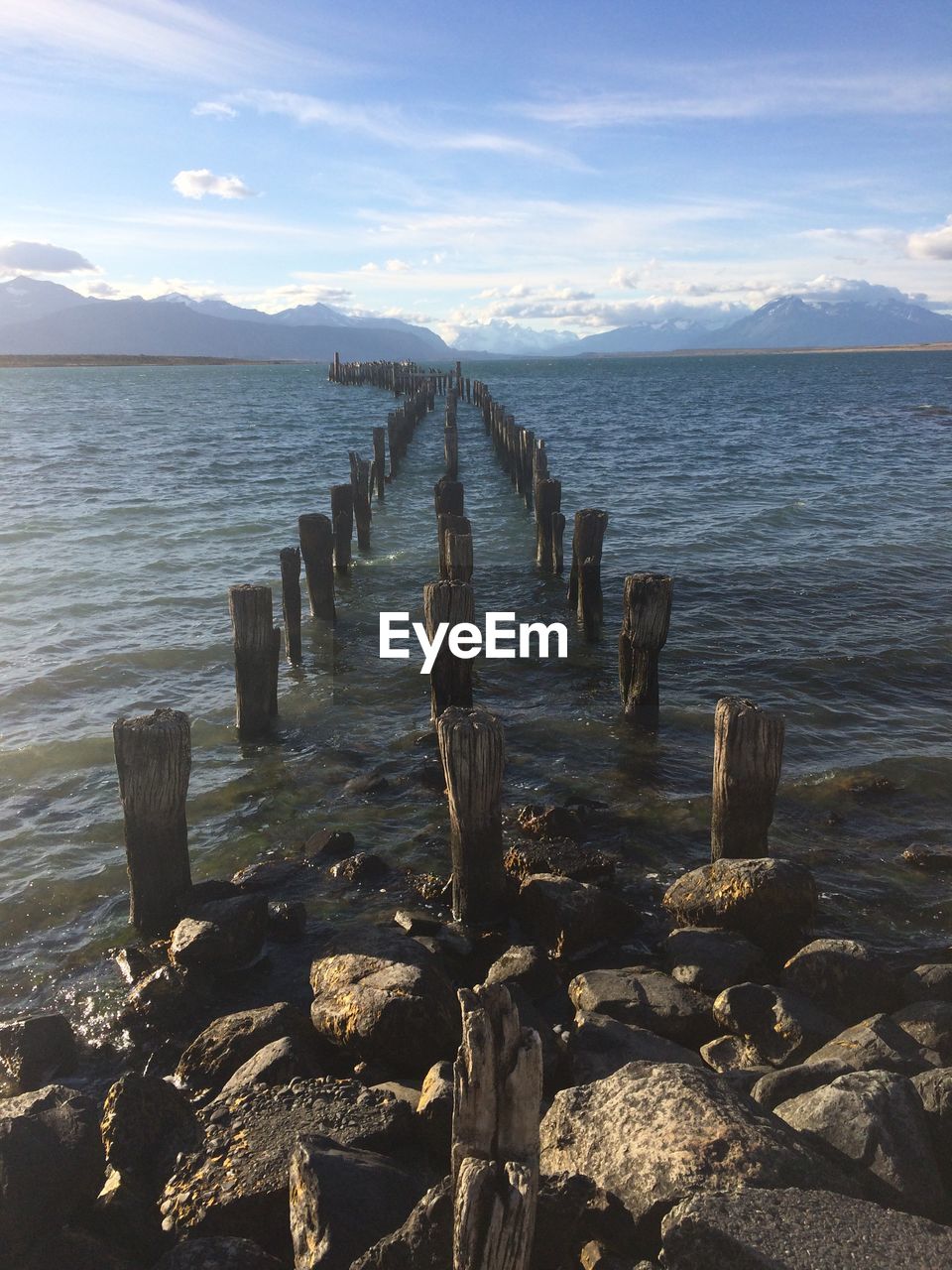 WOODEN POSTS ON BEACH