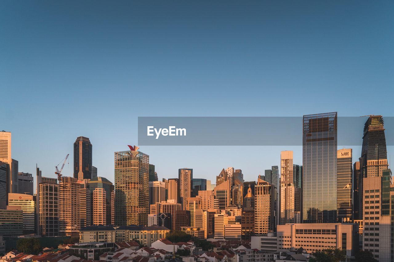 Buildings in city against clear sky