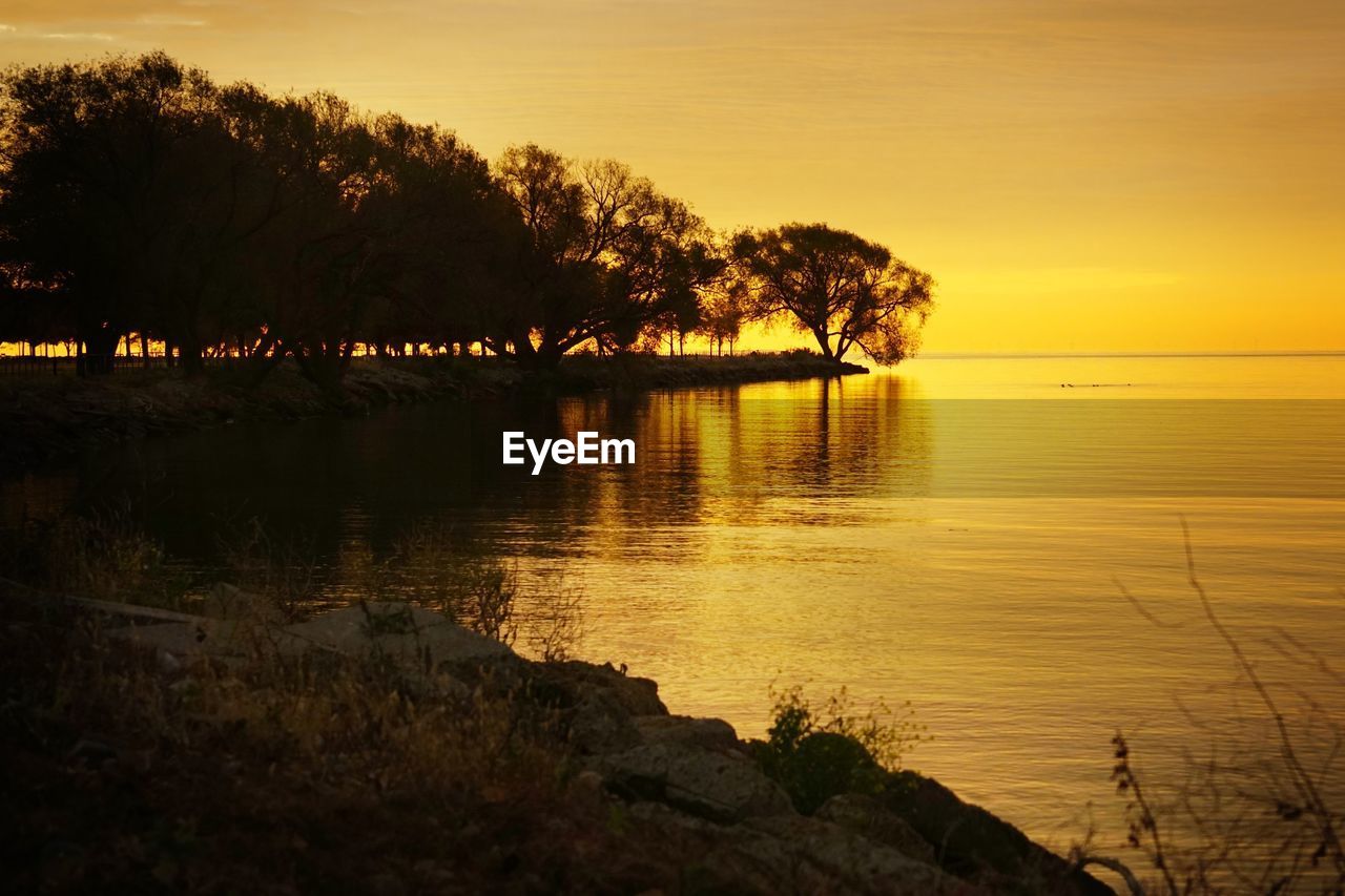 Scenic view of lake against sky during sunset