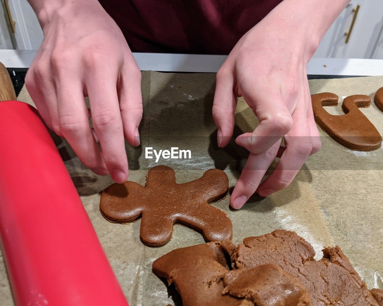 Close up of person's hands making gingerbread cookies 