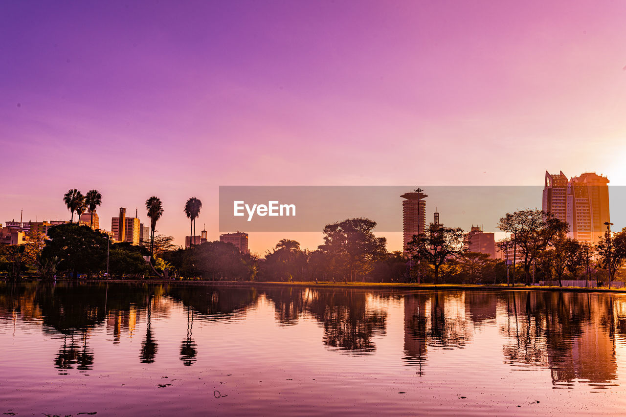reflection, sky, dusk, water, sunset, evening, architecture, skyline, city, landscape, built structure, nature, building exterior, horizon, cityscape, building, urban skyline, tree, twilight, environment, travel destinations, lake, sun, beauty in nature, outdoors, plant, skyscraper, tranquility, office building exterior, no people, travel, afterglow, scenics - nature, business finance and industry, cloud, pink, silhouette