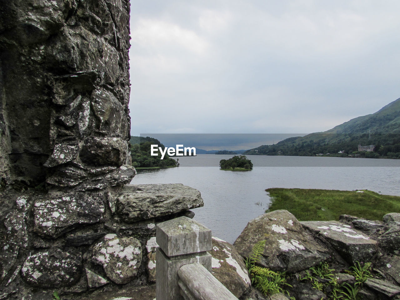 Scenic view of river against cloudy sky