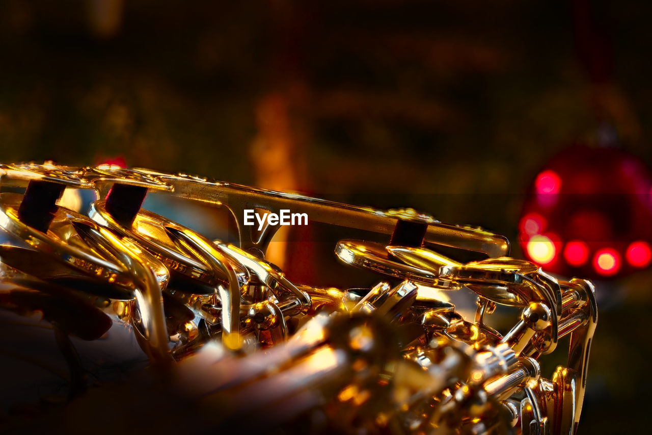 Close-up of hand of a saxophone in front of a chrismas tree