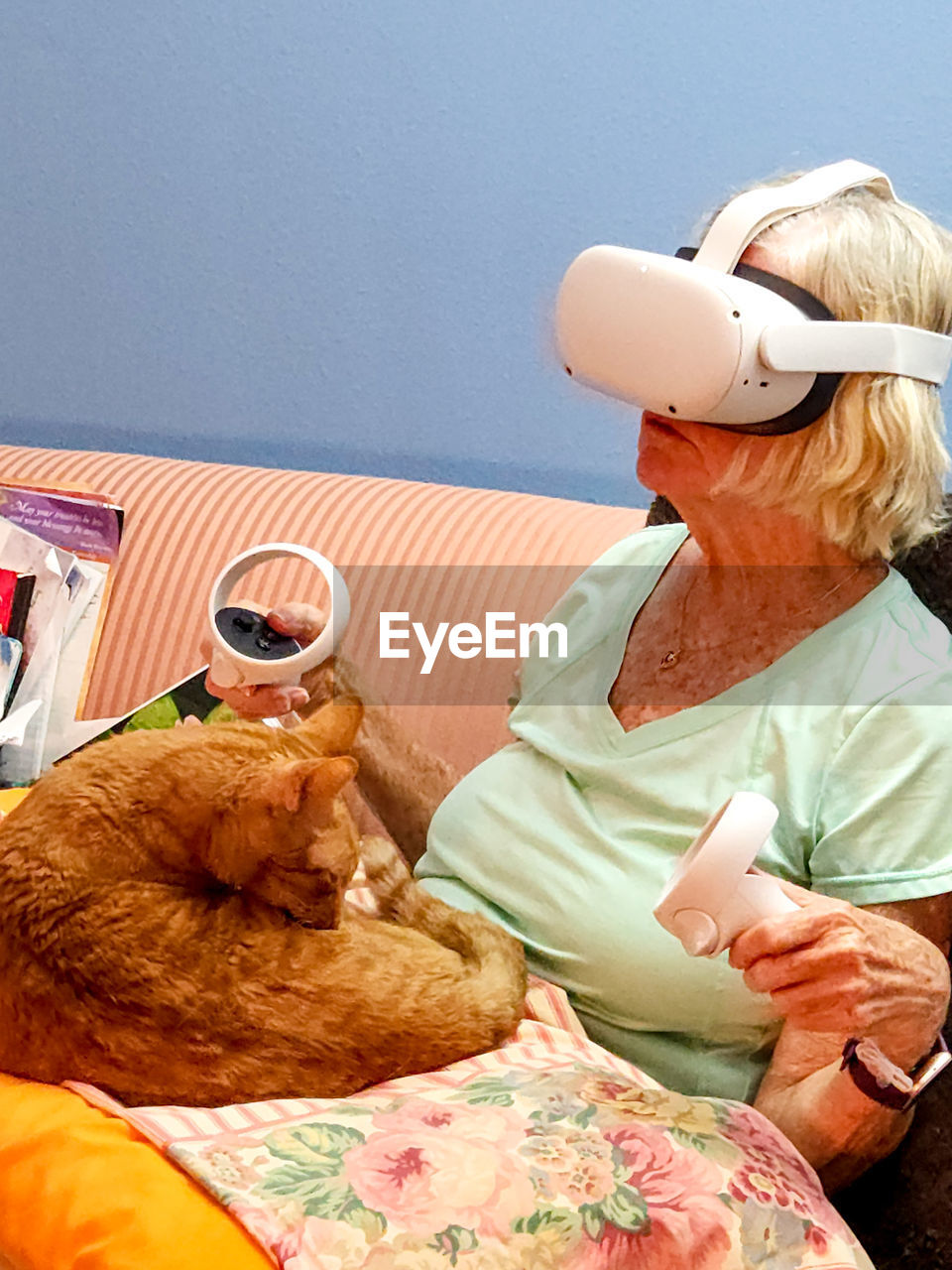 Side view of  elderly woman with cat wearing vr headset 