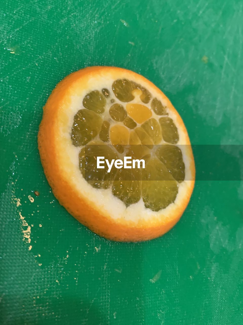 food and drink, fruit, food, healthy eating, plant, citrus, freshness, wellbeing, citrus fruit, slice, produce, no people, cross section, indoors, orange color, green, close-up, green background, still life, colored background, orange, studio shot, grapefruit, high angle view