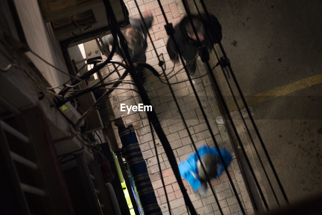 HIGH ANGLE VIEW OF MAN SHADOW ON FLOOR