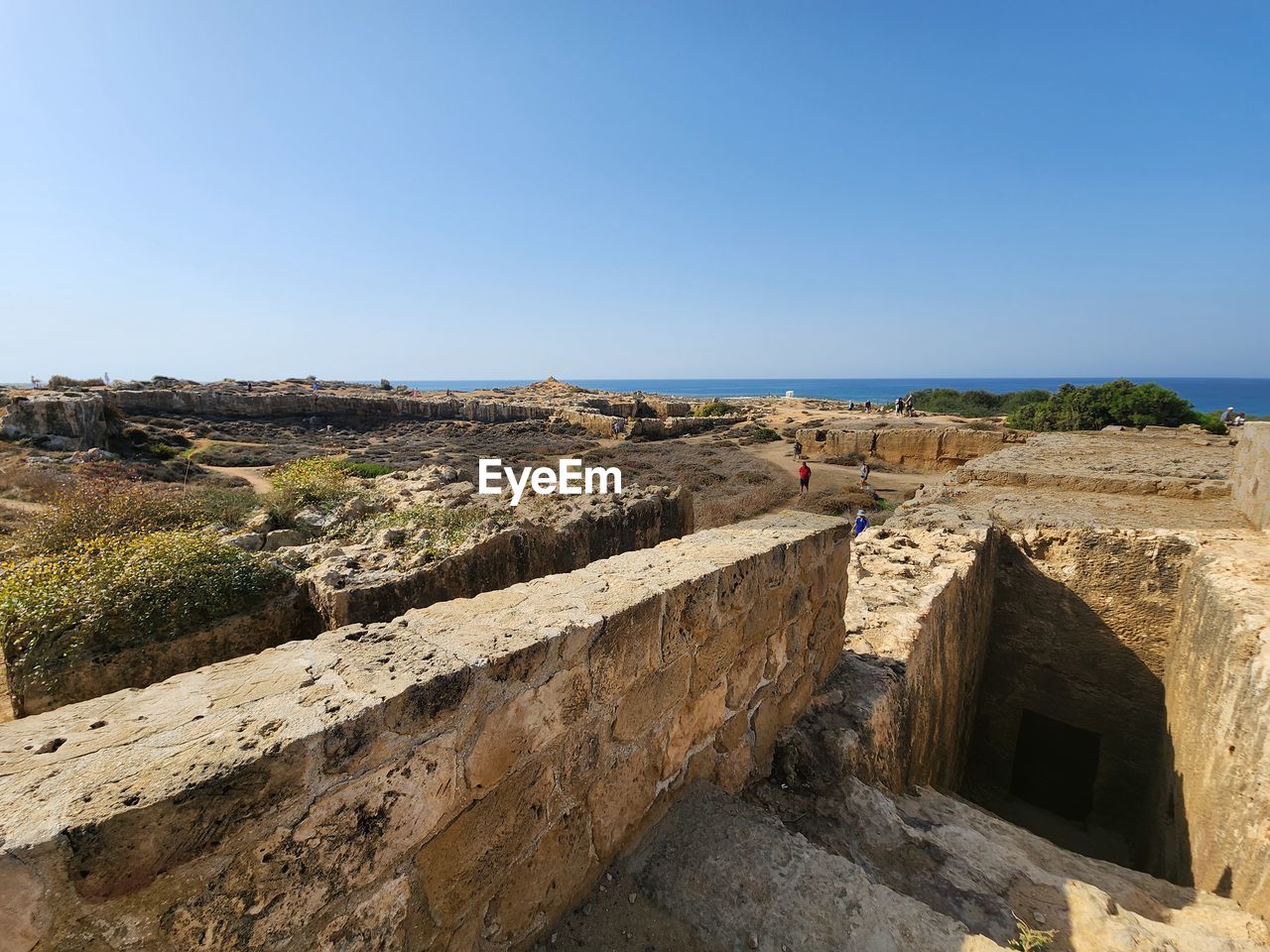 sky, architecture, fortification, history, nature, sea, clear sky, ruins, rock, cliff, the past, ancient history, travel destinations, land, travel, terrain, ancient, water, geology, built structure, blue, coast, tourism, scenics - nature, sunny, day, no people, landscape, environment, outdoors, old ruin, horizon, wall, copy space, vacation, ancient civilization, tranquility, beach, stone material, building exterior, sunlight, beauty in nature