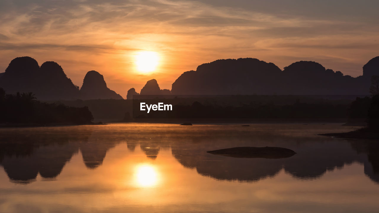 SCENIC VIEW OF SILHOUETTE MOUNTAIN AGAINST ORANGE SKY