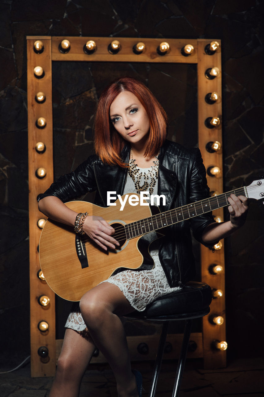 PORTRAIT OF A YOUNG WOMAN WITH A GUITAR