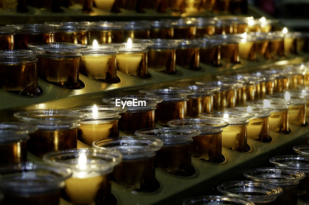 Close-up of lit tea lights in darkroom