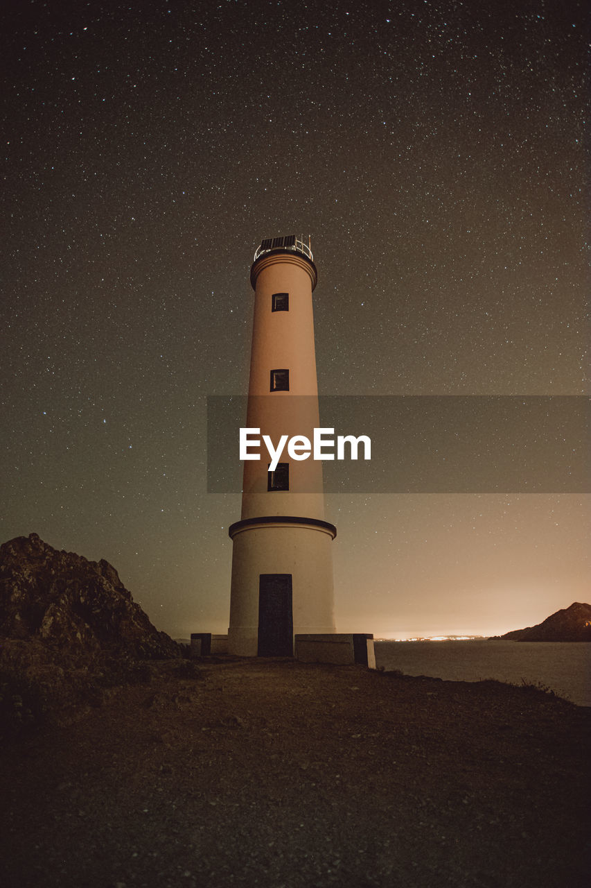 Lighthouse against sky at night