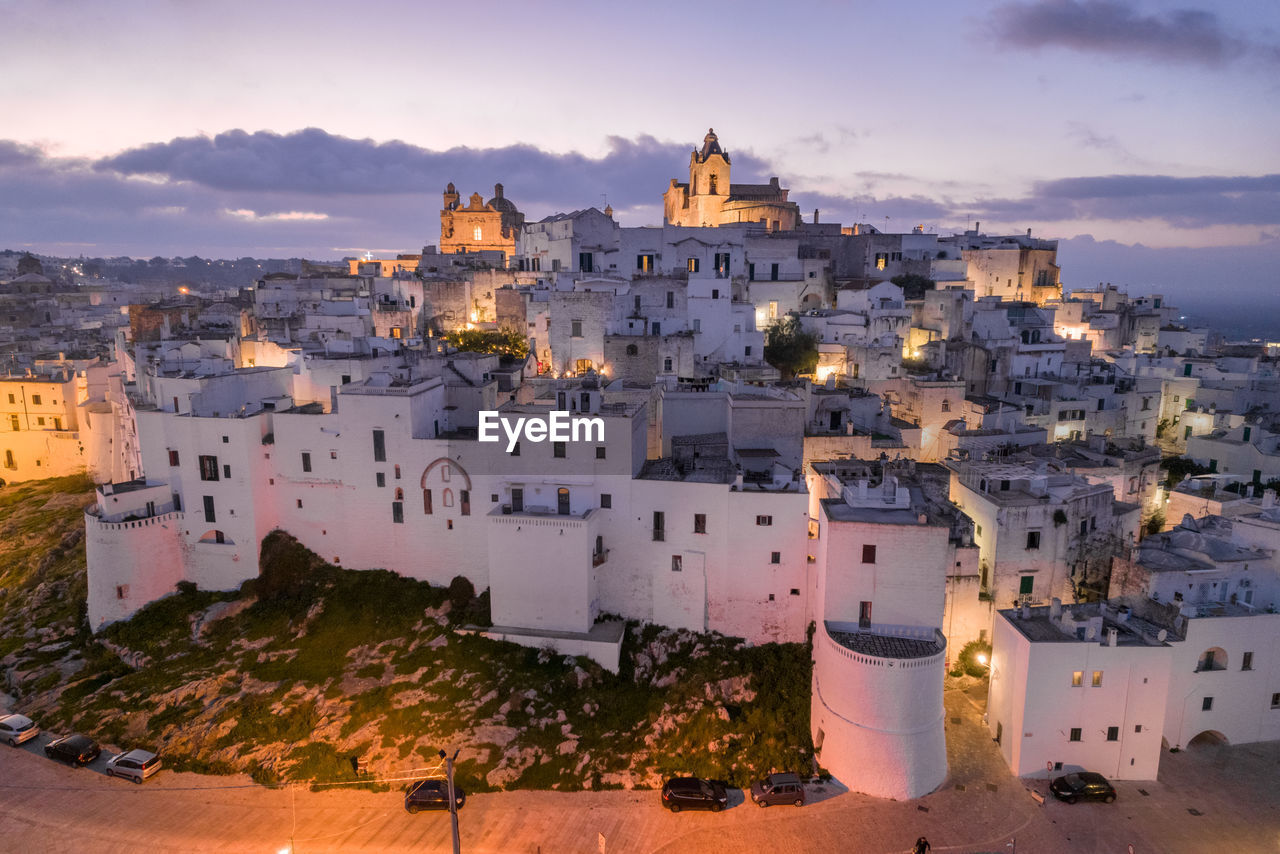 buildings in city against sky during sunset