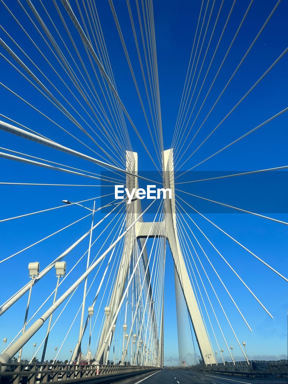 transportation, cable-stayed bridge, sky, blue, bridge, architecture, built structure, suspension bridge, city, nature, no people, road, clear sky, cable, line, the way forward, travel destinations, outdoors, travel, water, day, steel cable, mode of transportation, street, sunlight