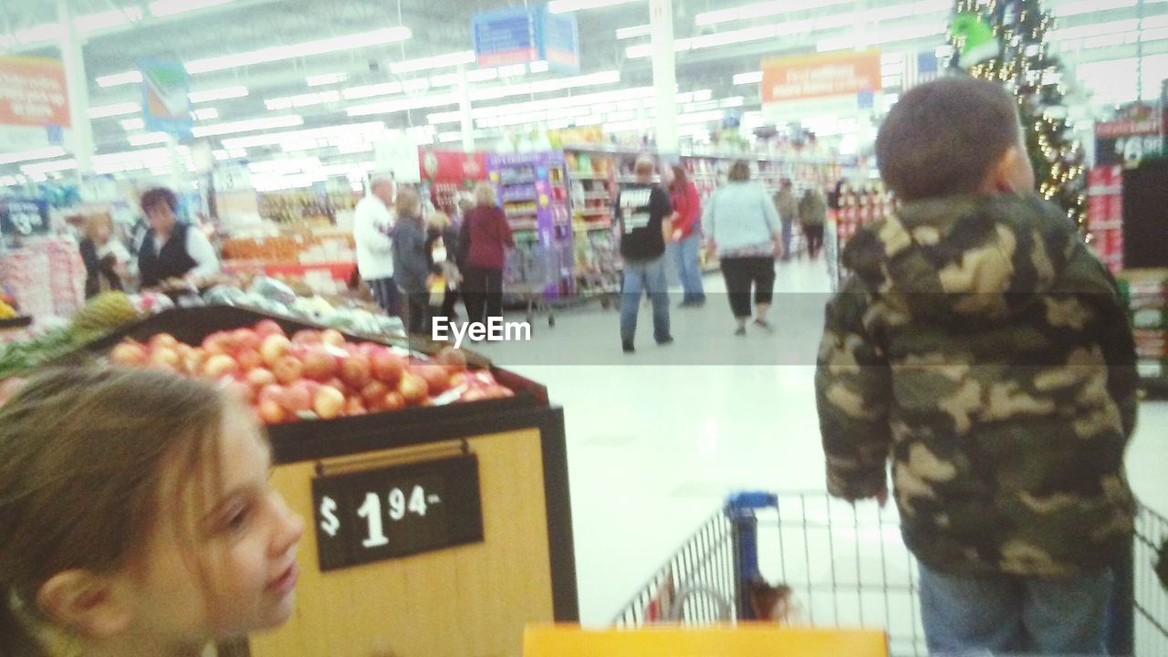 GROUP OF PEOPLE IN ILLUMINATED SHOP