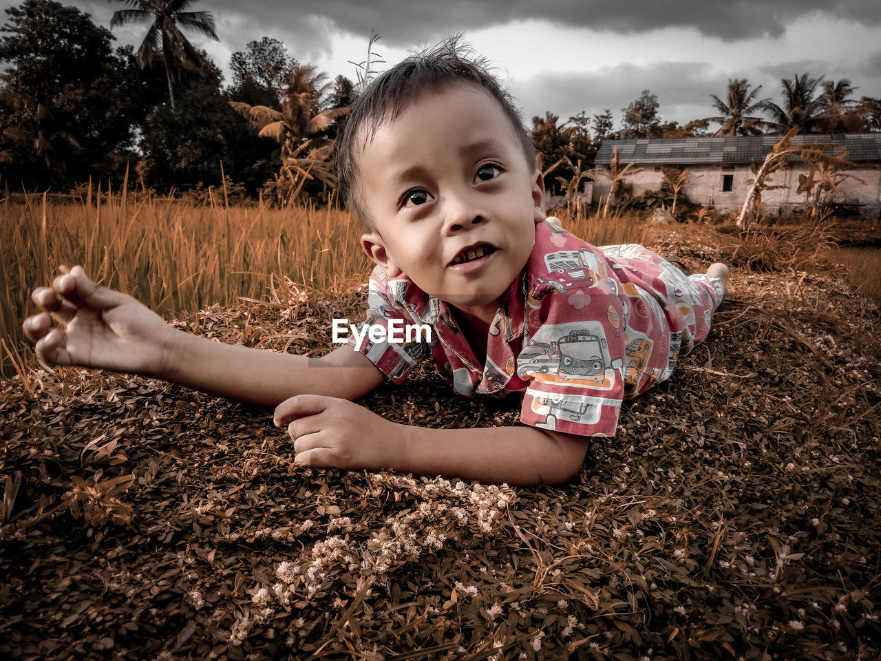 PORTRAIT OF SMILING GIRL LYING ON LAND